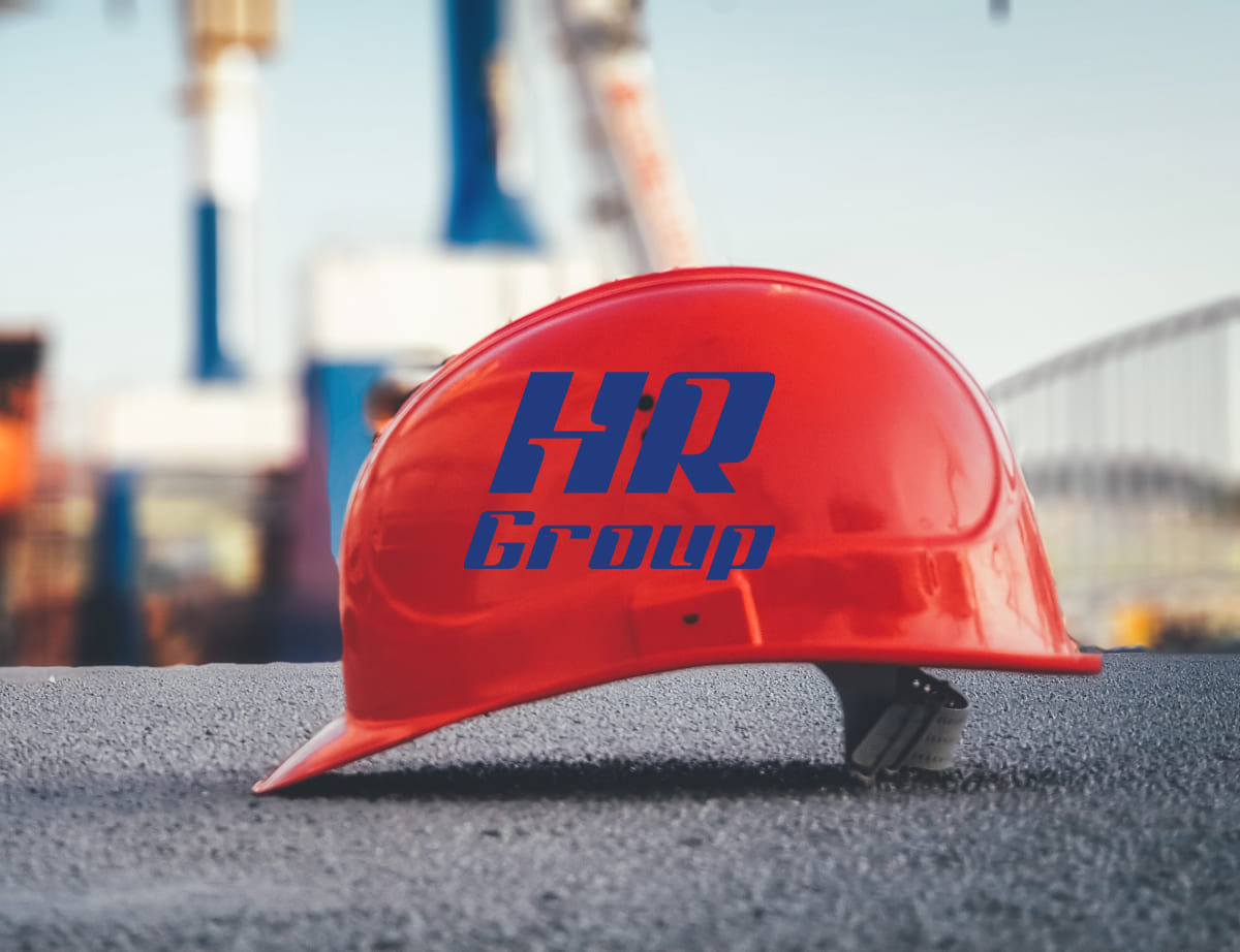 Logótipo da HR Group sobre fotografia de um capacete de obras