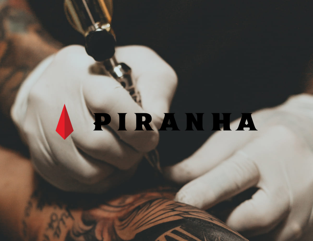 Logótipo da Piranha Tattoo Studios sobre fotografia de um tatuador a fazer uma tatuagem